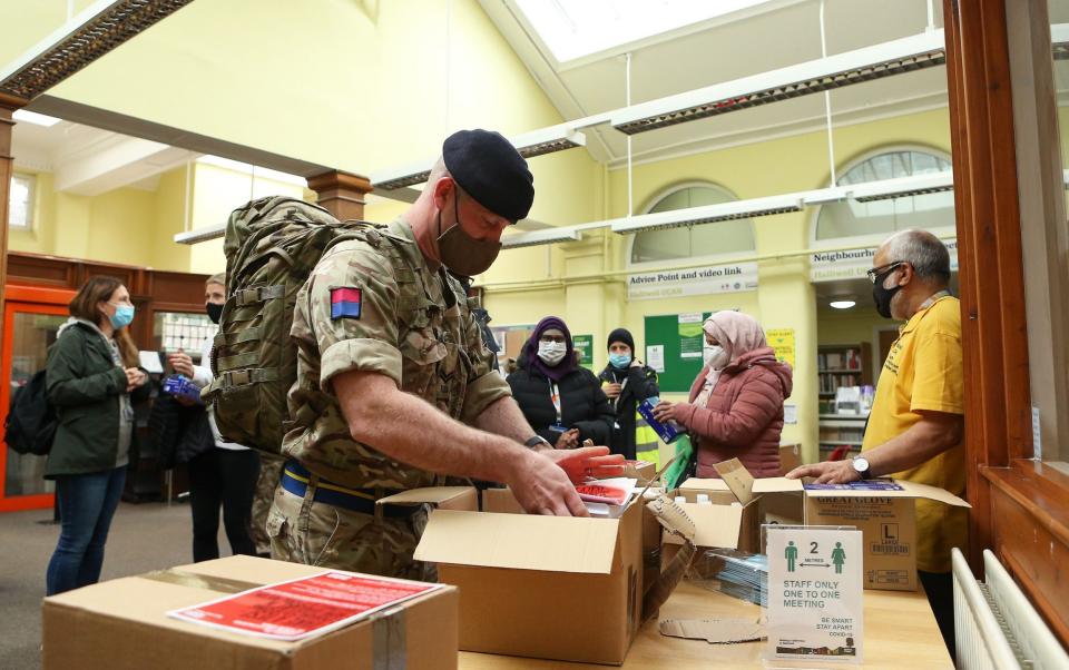 Members of the Armed Forces collect Covid-19 leaflets prior to distributing them to local residents of Halliwell - Charlotte Tattersall