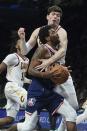 Cleveland Cavaliers forward Cedi Osman (16) fouls Brooklyn Nets guard Kyrie Irving (11) as he drives to basket during the second half of an NBA basketball game Friday April 8, 2022, in New York. (AP Photo/Bebeto Matthews)