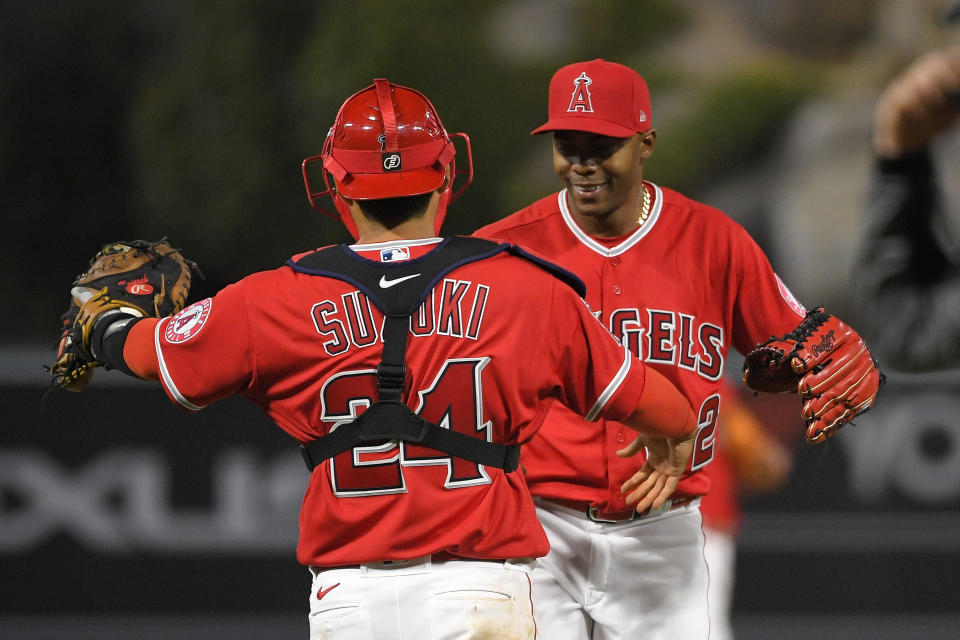 Los Angeles Angels catcher Kurt Suzuki, left, and relief pitcher Raisel Iglesias congratulate each other after the. Angels defeated the Texas Rangers 6-2 in a baseball game Tuesday, April 20, 2021, in Anaheim, Calif. (AP Photo/Mark J. Terrill)