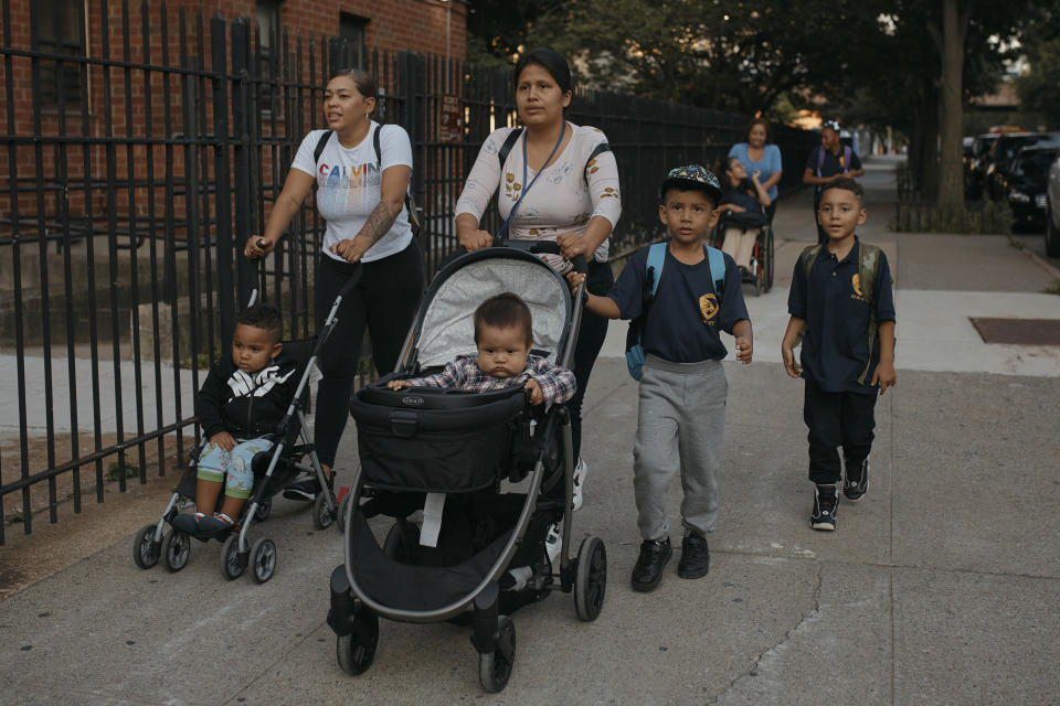 Kimberly Carchipulla, center top, and her son 5 year old Damien Salinas, center right, walk to school on Thursday, Sept. 7, 2023 in New York. Damien attends his first day of school in New York City after his family emigrated from Ecuador in June. Carchipulla and her family have been living in a room at the historic Roosevelt Hotel, converted into a city-run shelter for newly arrived migrant families hoping to find work, a new home and a better life for their children. (AP Photo/Andres Kudacki)