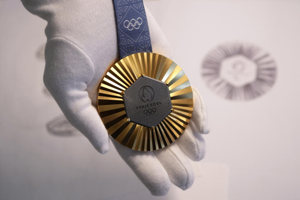 The Paris 2024 Olympic gold medal is presented to the press, in Paris, Thursday, Feb. 1, 2024. A hexagonal, polished piece of iron taken from the Eiffel Tower is being embedded in each gold, silver and bronze medal that will be hung around athletes' necks at the July 26-Aug. 11 Paris Games and Paralympics that follow. (AP Photo/Thibault Camus)