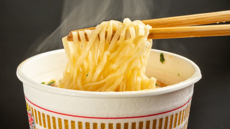 Cup noodles held in chopsticks