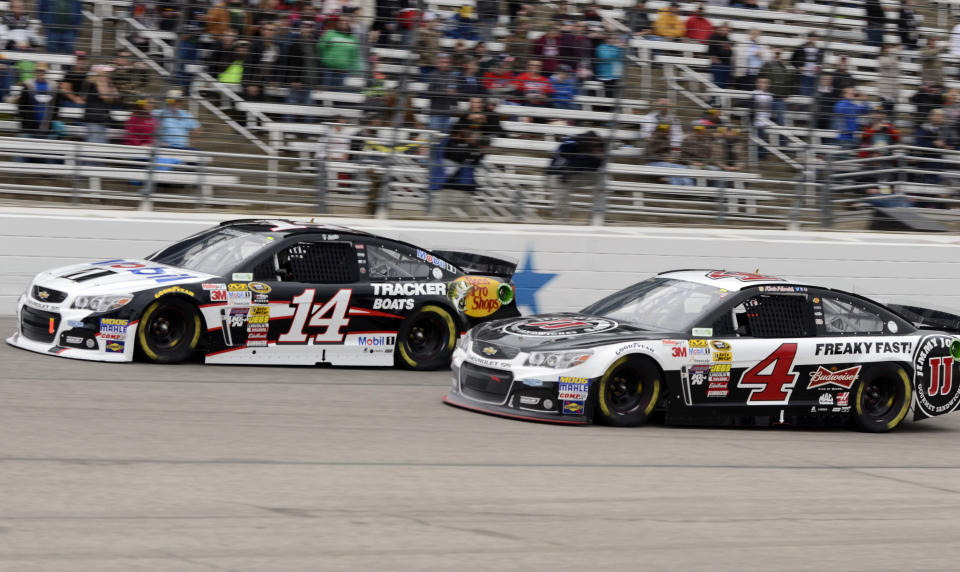 Tony Stewart (14) and Kevin Harvick (4) race through Turn 4 during the NASCAR Sprint Cup series auto race at Texas Motor Speedway, Monday, April 7, 2014, in Fort Worth, Texas. (AP Photo/Larry Papke)