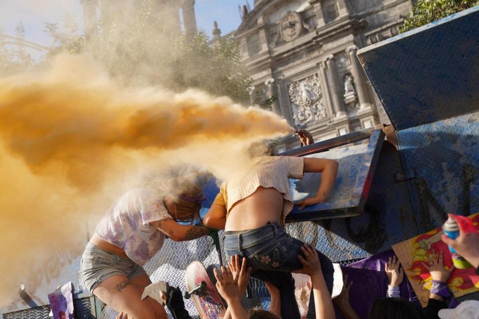 A police officer sprays demonstrators during a protest to mark International Women's Day in front of the National Palace in Mexico City on March 8.<span class="copyright">Toya Sarno Jordan—Reuters</span>