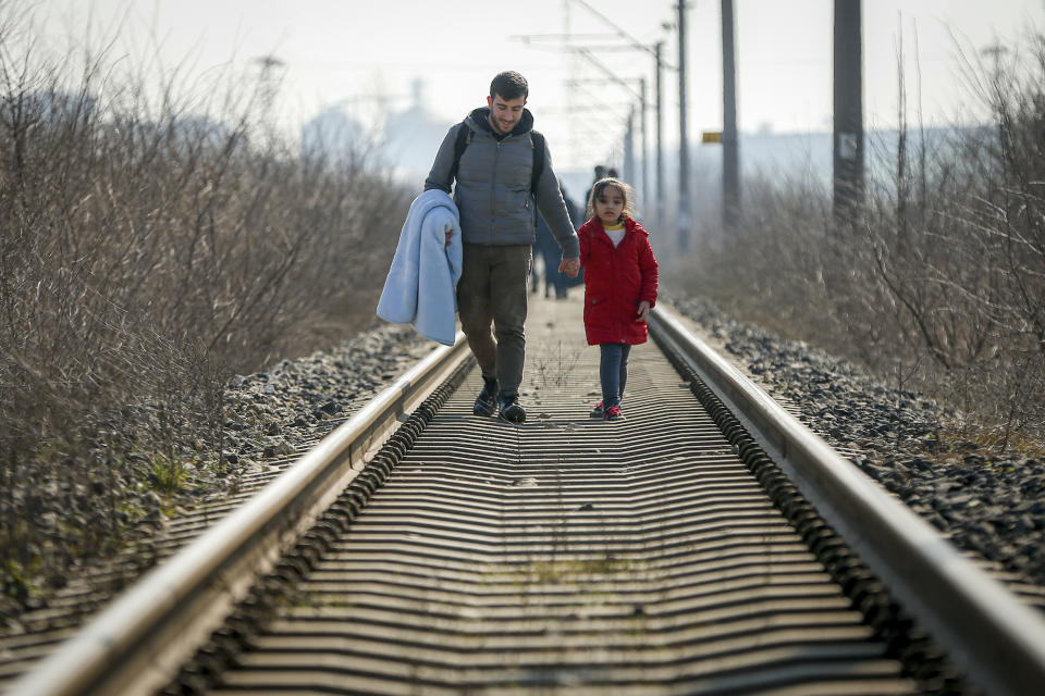 Migrants walk on the railway tracks heading for Greece near the Pazarakule border crossing in Edirne, Turkey, Sunday, March. 1, 2020. The United Nations migration organization said Sunday that at least 13,000 people were massed on Turkey's land border with Greece, after Turkey officially declared its western borders were open to migrants and refugees hoping to head into the European Union. (AP Photo/Emrah Gurel)
