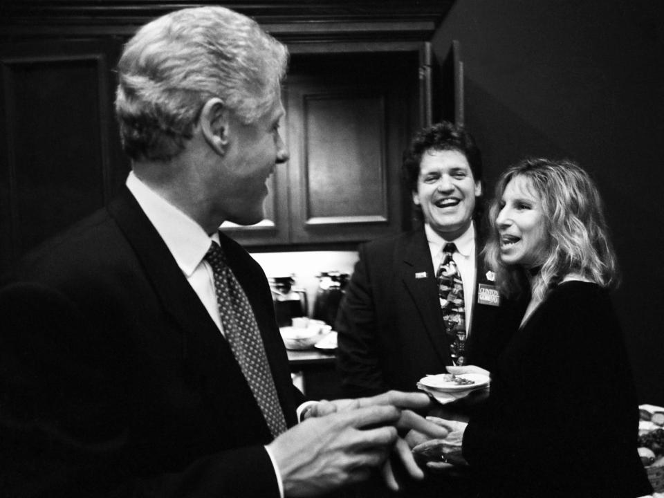 President Bill Clinton talks with singer-songwriter Barbra Streisand and his half-brother Roger Clinton on election night backstage at the Old State House, Little Rock, Arkansas, November 5, 1996.