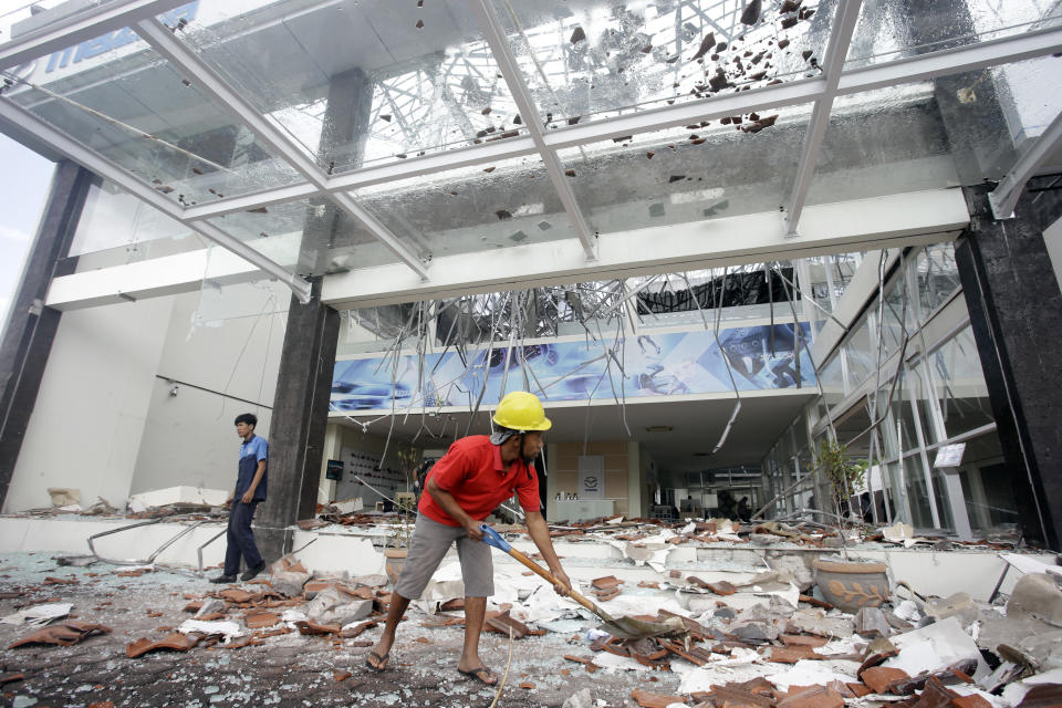 Trabajadores limpian los escombros en un edificio dañado por un sismo en Bali, Indonesia, el 6 de agosto de 2018. (AP Foto/Firdia Lisnawati)