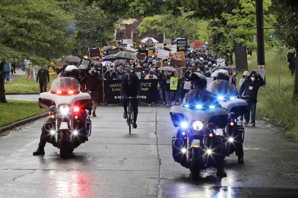 Police on motorcycles ride ahed of protesters taking part in a "Silent March" against racial inequality and police brutality that was organized by Black Lives Matter Seattle-King County, Friday, June 12, 2020, in Seattle. Hundreds of people marched for nearly two miles to support Black lives, oppose racism and to call for police reforms among other issues. (AP Photo/Ted S. Warren)