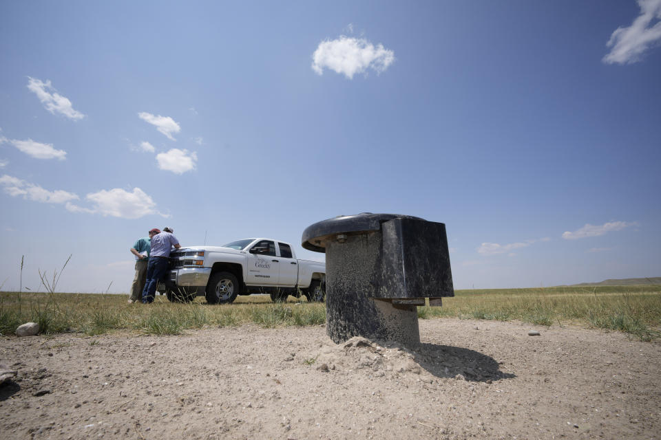 In this Monday, July 26, 2021, photograph, a well head is shown on the Terry Bison Ranch as Cole Gustafson, a water resource administrator for the Greeley, Colo., Water Department, works near his pickup truck near Carr, Colo. Figures released this month show that population growth continues unabated in the South and West, even as temperatures rise and droughts become more common. That in turn has set off a scramble of growing intensity in places like Greeley to find water for the current population, let alone those expected to arrive in coming years. (AP Photo/David Zalubowski)