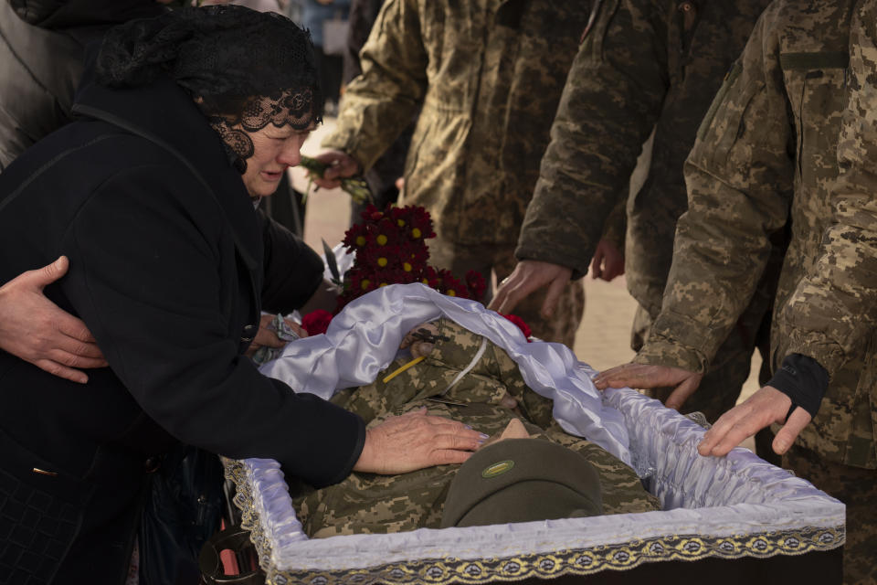 Tetiana Hurieieva, the mother of Volodymyr Hurieiev, a Ukrainian soldier killed in the Bakhmut area, cries during the funeral in Boryspil, Ukraine, Saturday, March 4, 2023. Pressure from Russian forces mounted Saturday on Ukrainians hunkered down in Bakhmut, as residents attempted to flee with help from troops who Western analysts say may be preparing to withdraw from the key eastern stronghold. (AP Photo/Vadim Ghirda)