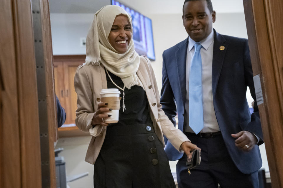 Rep. Ilhan Omar, D-Minn., a target of racist rhetoric from President Donald Trump, is joined at right by fellow freshman Rep. Joe Neguse, D-Colo., as she walks to her office following votes, at the Capitol in Washington, Thursday, July 18, 2019. (AP Photo/J. Scott Applewhite)