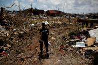 FILE PHOTO: A police officer searches for the dead in the destroyed Mudd neighborhood after Hurricane Dorian hit the Abaco Islands in Marsh Harbour