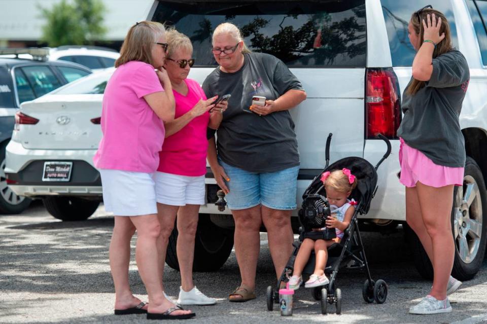 Protestors in support of Heather Wyatt and Aubreigh Wyatt try to keep cool in the shade as they wait outside the Jackson County Courts building on Thursday, July 18, 2024, as Heather Wyatt participates in a chancery court hearing inside the courthouse.