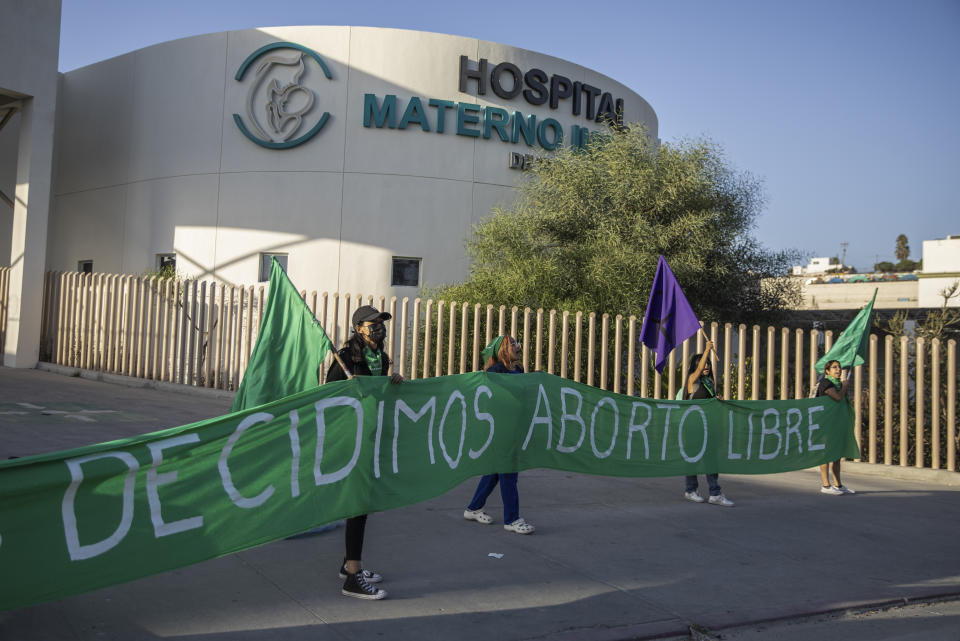 Miembros de la organización de derechos reproductivos Colectiva Bloodys y Projects sostienen una pancarta con el lema "Decidimos aborto libre" en el exterior de un hospital público en Tijuana, México, el 28 de septiembre de 2023. La organización ha respaldado los derechos reproductivos cerca de la frontera entre México y Estados Unidos desde 2016. (AP Foto/Karen Castaneda)