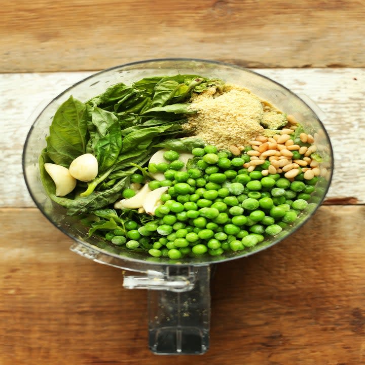 Ingredients for pea pesto in a food processor.