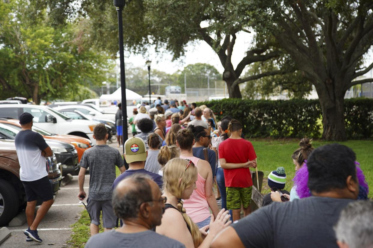 Tampa residents wait for over 2 hours at Himes Avenue Complex to fill their 10 free sandbags on Sunday, Sept. 25, 2022, in Tampa, Fla. Authorities and residents in Florida are keeping a cautious eye on Tropical Storm Ian as it rumbles through the Caribbean.