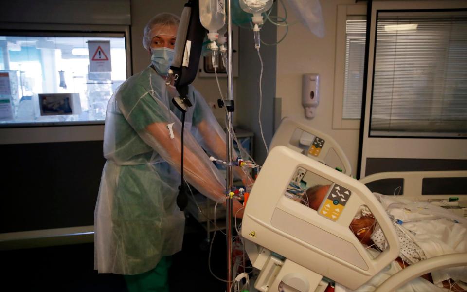 A medical worker moves a patient affected with the COVID-19 in the Amiens Picardie hospital. France is now facing a deadly new surge of the virus that is overwhelming many hospitals. - AP Photo/Francois Mori