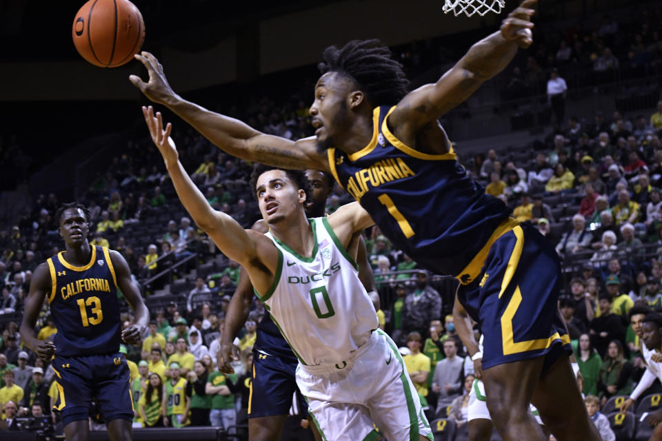 Oregon guard Will Richardson (0) and California guard Joel Brown (1) reach for the ball during the first half of an NCAA college basketball game Thursday, March 2, 2023, in Eugene, Ore. (AP Photo/Andy Nelson)