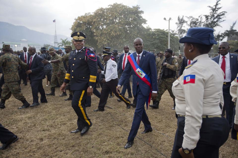 Haiti's President Jovenel Moise walks with Police chief Michel-Ange Gedeon past National Police at the National Palace after being sworn-in at Parliament in Port-au-Prince, Haiti, Tuesday Feb. 7, 2017. Moise was sworn as president for the next five years after a bruising two-year election cycle, inheriting a struggling economy and a deeply divided society. (AP Photo/Dieu Nalio Chery)