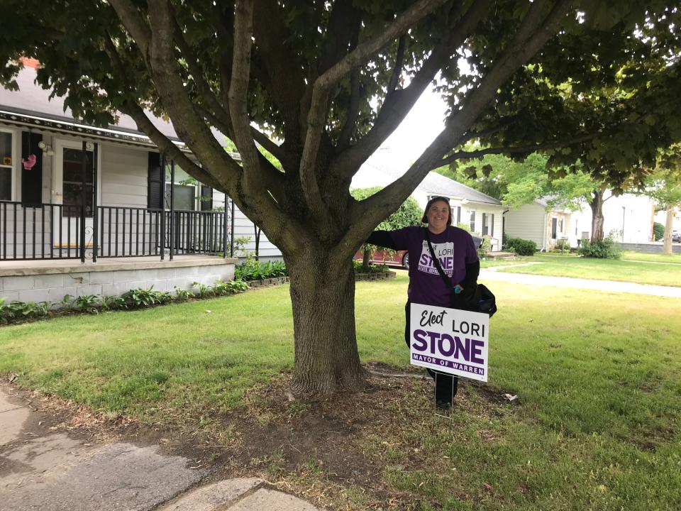 State Rep. Lori Stone, D-Warren, poses with her campaign sign as she knocks on voters doors to ask for their support for her mayoral bid on June 12, 2023.