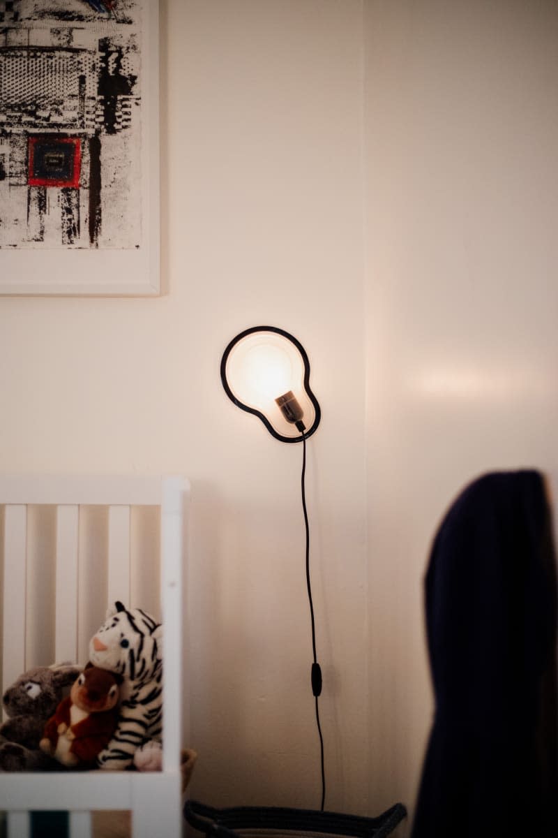 Light sconce hung on wall in kids room.