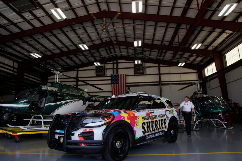 Sheriff Eric Flowers, along with sponsors and local representatives gather at the Indian River County Sheriff’s Office hangar, Wednesday, July 26, 2023, to unveil their autism awareness vehicle.