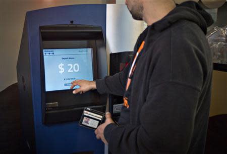 A customer uses the world's first ever permanent bitcoin ATM unveiled at a coffee shop in Vancouver, British Columbia October 29, 2013. REUTERS/Andy Clark