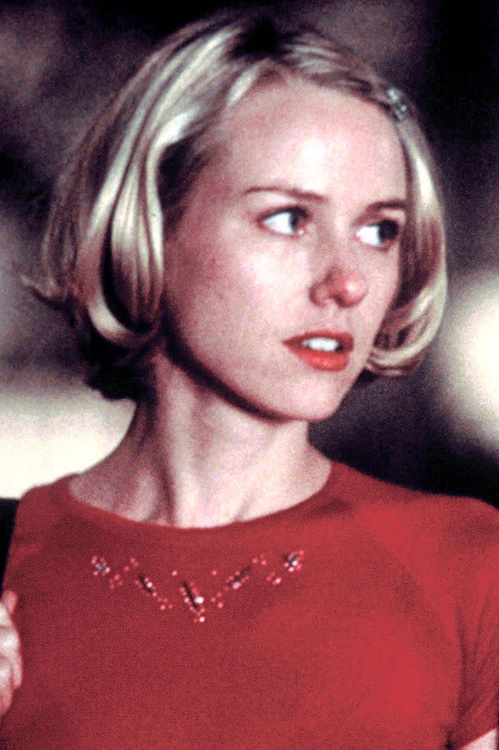 A young Naomi Watts engaged in a conversation with another woman in a scene from 