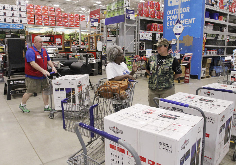 FILE - In this Sept. 3, 2019, file photo store associates help customers with generators and supplies at Lowes in New Bern, N.C., as residents bracing for potential storm weather. Backup power options range from gasoline-powered portable generators, which can cost $1,000 or more, to solar panels plus batteries, which cost tens of thousands of dollars to purchase and install. (Gray Whitley/Sun Journal via AP, File)