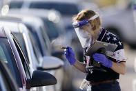 An election worker instructs a voter at a drive-thru polling location Tuesday, Nov. 3, 2020, in Kansas City, Mo. The location was established to provide access for people who have tested positive for COVID-19 and elderly voters. (AP Photo/Charlie Riedel)