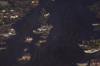 Lava from a volcano eruption engulfs houses on the island of La Palma in the Canaries, Spain, Thursday, Sept. 23, 2021. A volcano on a small Spanish island in the Atlantic Ocean erupted on Sunday, forcing the evacuation of thousands of people. Experts say the volcanic eruption and its aftermath on a Spanish island could last for up to 84 days. (AP Photo/Emilio Morenatti, Pool)