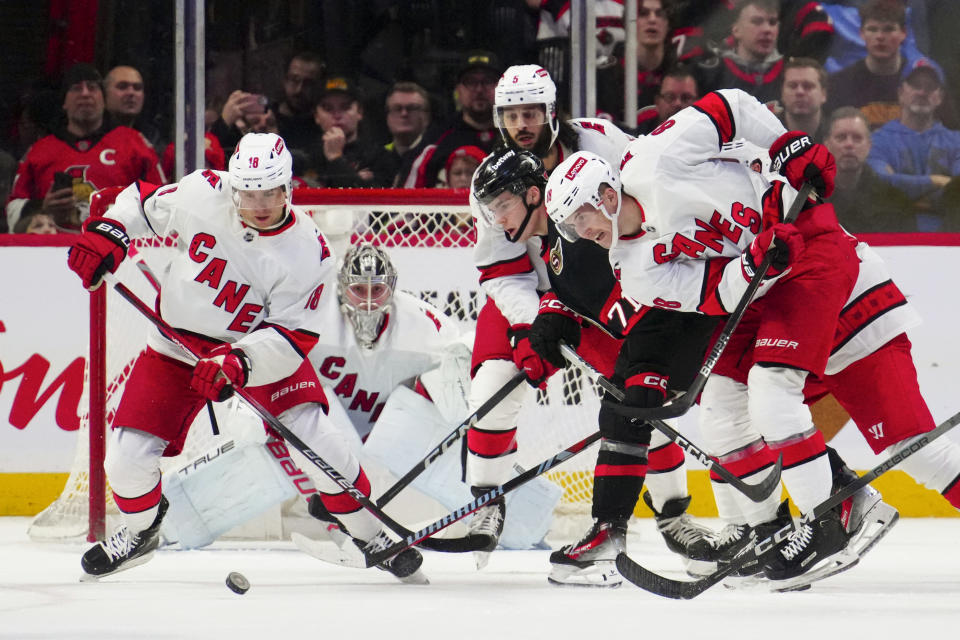 Carolina Hurricanes center Jack Drury (18), Hurricanes goaltender Pyotr Kochetkov (52), Hurricanes defenseman Jalen Chatfield (5), Hurricanes center Martin Necas (88) and Ottawa Senators center Ridly Greig (71) take part in a battle for the puck during the first period of an NHL hockey match in Ottawa, Ontario, on Tuesday, Dec. 12, 2023. (Sean Kilpatrick/The Canadian Press via AP)