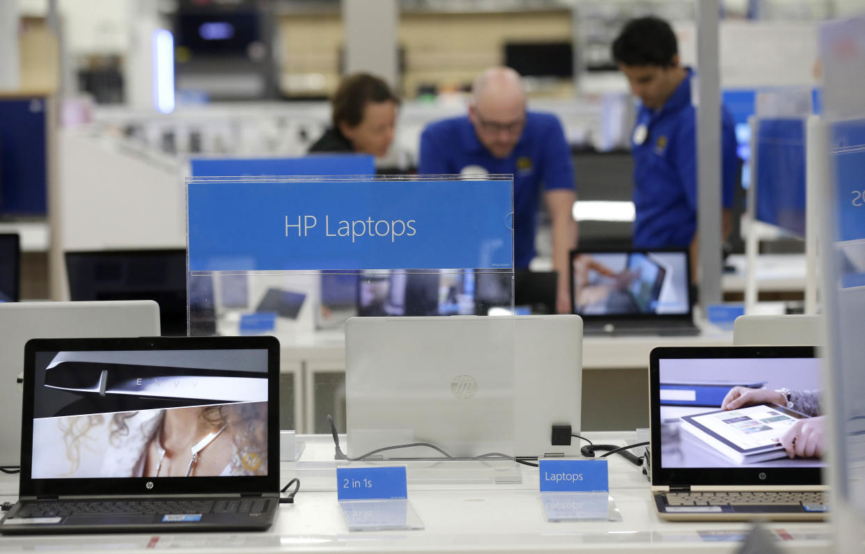 In this photo taken Tuesday, May 23, 2017 employees assist a customer with a computer at Best Buy in Cary, N.C. (AP Photo/Gerry Broome)