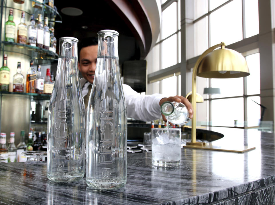 This undated image provided by Hyatt shows a water station with reusable water bottles. Hyatt Hotels Corp. is the latest hotel company to remove small bottles from its bathrooms in an effort to reduce waste. Hyatt is also cutting down on the use of plastic water bottles at meetings and events and increasing the number of water stations in its hotels so guests can refill their own water bottles. (Courtesy of Hyatt via AP)