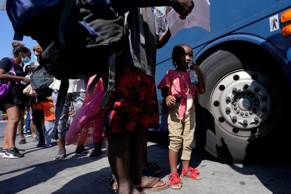 Migrants, many from Haiti, board a bus after they were processed and released after spending time at a makeshift camp near the International Bridge, Monday, 20 September 2021, in Del Rio, Texas (AP)