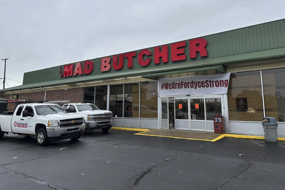 Trucks sit parked in front of the Mad Butcher grocery store in Fordyce, Ark., Wednesday, June 26, 2024. The store has remained closed in the days following a mass shooting that killed four people, prompting volunteers to scramble to set up food distribution sites for residents. (AP Photo/Andrew DeMillo)