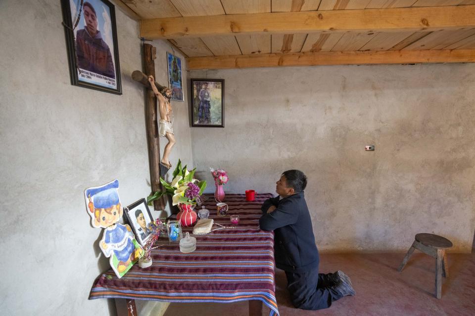 Marco Antulio Pablo Perez prays at an altar for his son Anderson Pablo in Comitancillo, Guatemala, Wednesday, March 20, 2024. The 16-year-old died among the migrants who were shot and set afire by rogue police officers in Camargo, Mexico, in January 2021. (AP Photo/Moises Castillo)