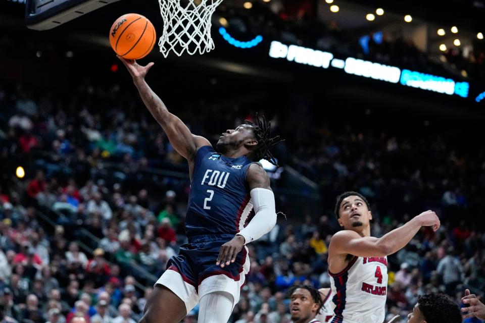 Fairleigh Dickinson guard Demetre Roberts (2) scores behinds Florida Atlantic guard Bryan Greenlee (4) in the first half of a second-round college basketball game in the men's NCAA Tournament in Columbus, Ohio, Sunday, March 19, 2023. (AP Photo/Michael Conroy)