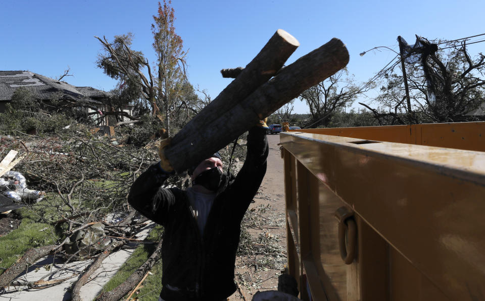 Ian Hardy tosses trees fallen by a tornado into a dumpster in Dallas, Tuesday, Oct. 22, 2019. The National Weather Service says nine tornadoes struck the Dallas area during Sunday's stretch of severe storms in Texas. (AP Photo/LM Otero)