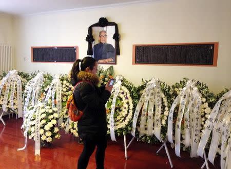 A woman takes pictures of wreaths sent by Chinese President Xi Jinping and other leaders to Zeng Yanxiu at Zeng's flat, in Beijing, March 10, 2015. REUTERS/Benjamin Kang Lim/Files