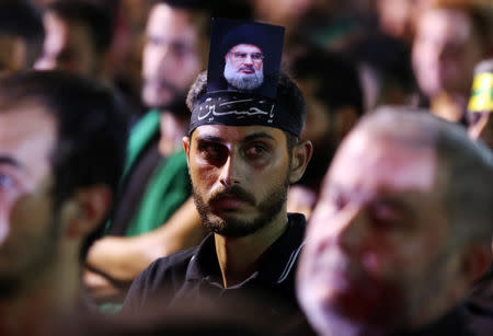 A supporter of Lebanon's Hezbollah leader Sayyed Hassan Nasrallah has his picture on his head, during a live broadcast, the night before Muslim Shi'ites around the world mark the day of Ashura, in Beirut, Lebanon September 19, 2018. REUTERS/Hasan Shaaban