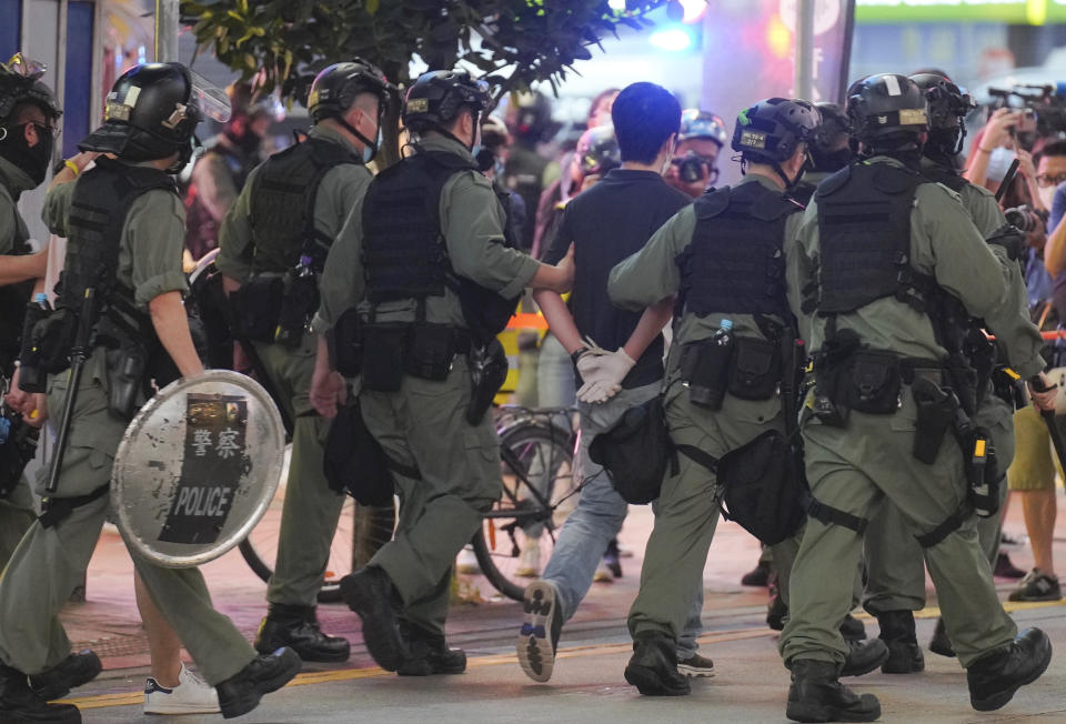 FILE - Hui Chi-fung, center, a Democratic Party politician, is detained by riot police during a protest in Causeway Bay, Hong Kong, on June 12, 2020. Hong Kong began work on a local National Security Law on Tuesday, Jan. 30, 2024, more than three years after Beijing imposed a similar law that has all but wiped out dissent in the semi-autonomous city. Since 2020, many of the city’s leading pro-democracy activists have been arrested, silenced or forced into exile. Dozens of civil society groups have been disbanded, and outspoken media outlets have been shut down. (AP Photo/Vincent Yu, File)