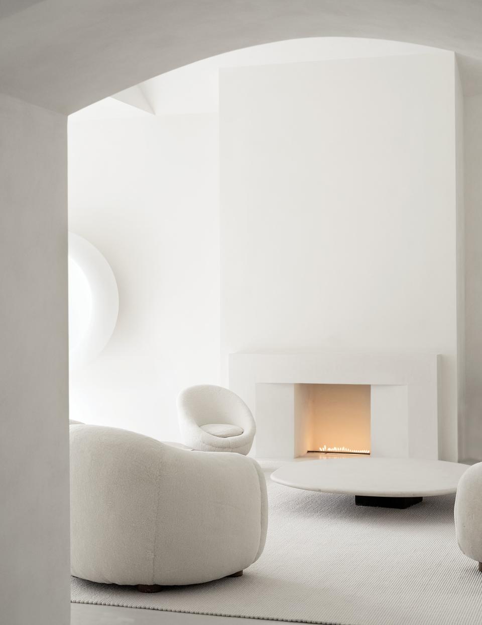 In the living room, Royère upholstered seating surrounds a limestone cocktail table by Axel Vervoordt.