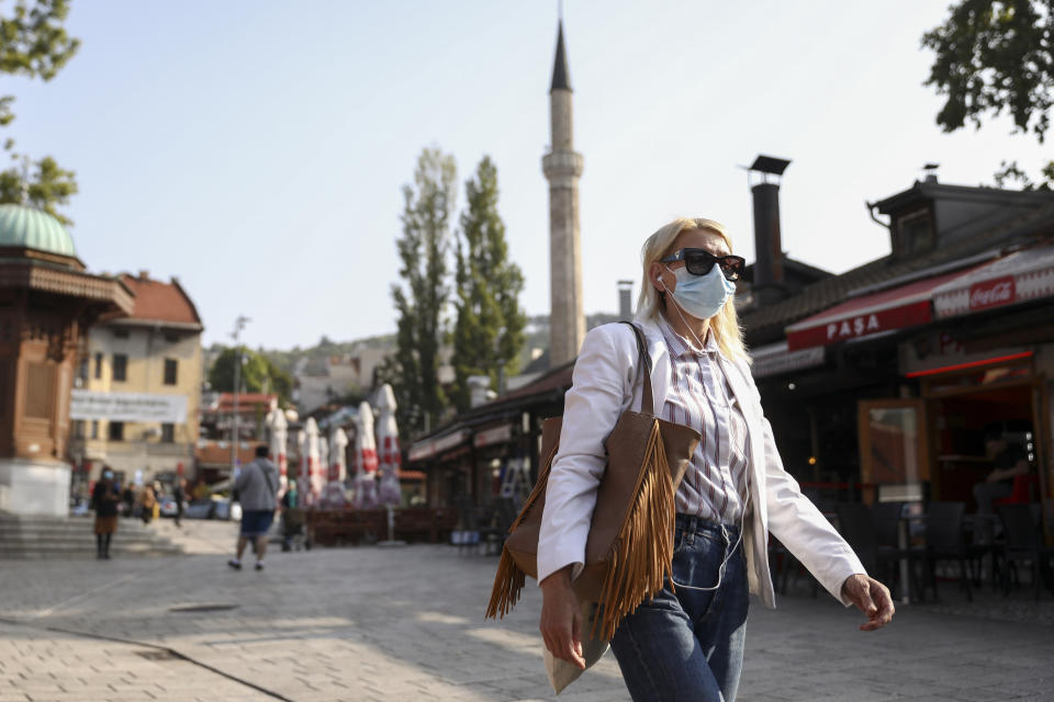 A woman wears a face mask while walking downtown Sarajevo, Bosnia, Monday, Sept. 27, 2021. Public mistrust of authorities in corruption-plagued Bosnia has created an opening for anti-vaccination movement even though the Balkan nation has the highest rate in Europe of coronavirus deaths and faces a growing number of new infections. So far, despite an abundance of coronavirus vaccines in Bosnia, just under 13 percent of its 3.3 million people had been fully immunized against Covid-19. (AP Photo)