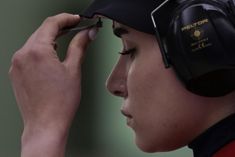 Iran's Haniyeh Rostamiyan adjusts her blinder during the Shooting 10m Air Pistol Mixed Team bronze medal match against Pakistan for the 19th Asian Games in Hangzhou, China, Saturday, Sept. 30, 2023. (AP Photo/Ng Han Guan)