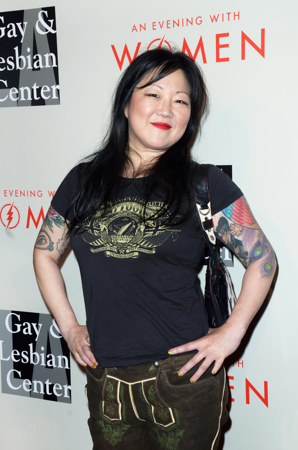 Margaret Cho at the Gay & Lesbian Center's "An Evening with Women" event, wearing a black graphic T-shirt and brown pants, smiling with hands on hips