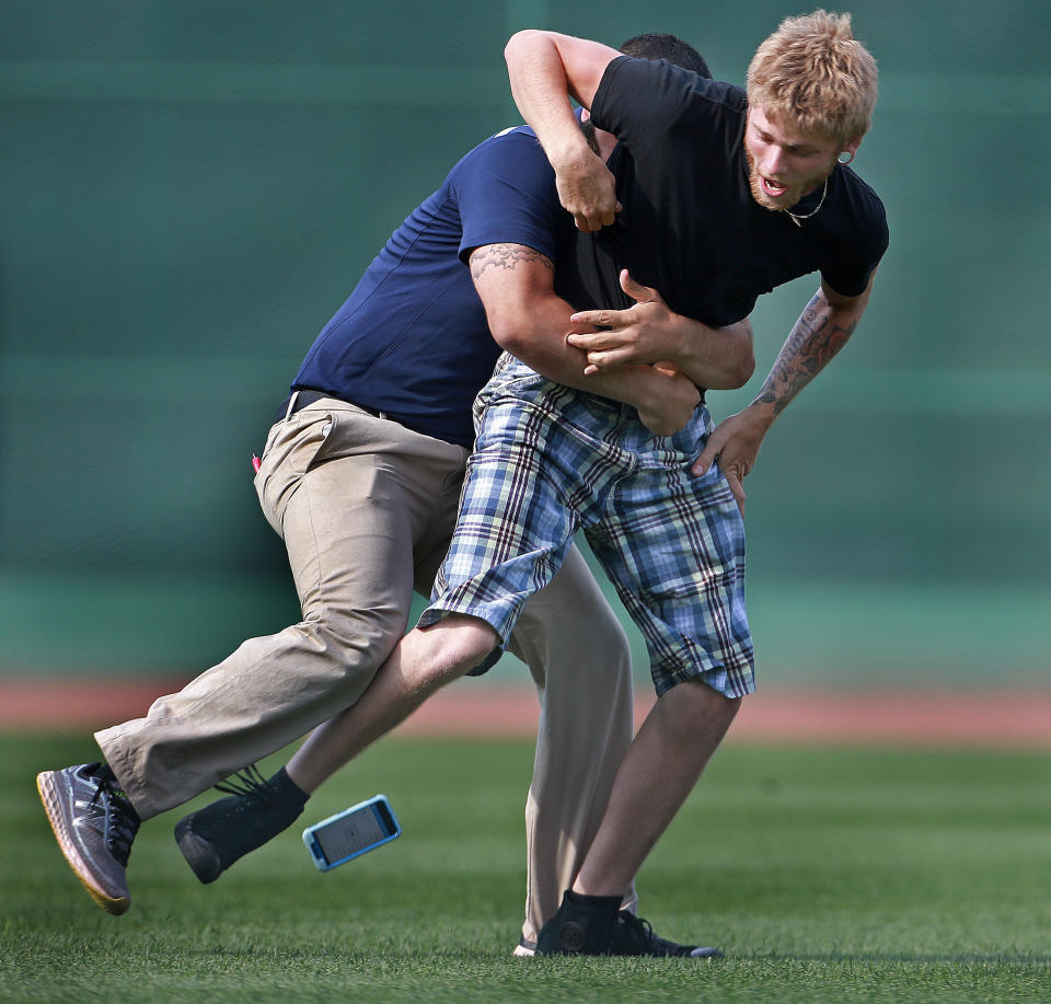 With the Red Sox getting crushed again by the Blue Jays on the way to getting swept for the second straight series, the only late in the game excitement on the field came when two fans jumped out of the stands and raced across the field in the bottom of the ninth inning. One of them appeared to be recording himself as he ran from left field towards right field. When he was brought down by a Fenway Park security guard in right field and lost his phone while being tackled. The Boston Red Sox hosted the Toronto Blue Jays in a regular season MLB baseball game at Fenway Park. (Photo by Jim Davis/The Boston Globe via Getty Images)