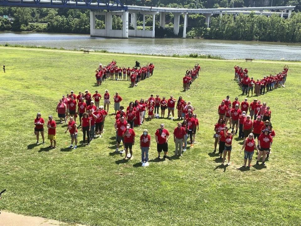 Activists, forming the phrase “HIV SOS,” are calling on the city of Charleston, W.Va., to declare a public health emergency for new HIV cases and prescription drug overdoses.