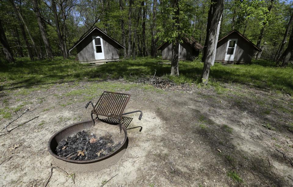 This Tuesday, May 14, 2013, file photo shows a fire pit and cabins at the Camp Conestoga Girls Scouts camp, in New Liberty, Iowa. In 2013, financial stress has prompted many local councils to consider selling off old summer camps, both to gain revenue and reduce maintenance costs. (AP Photo/Charlie Neibergall)