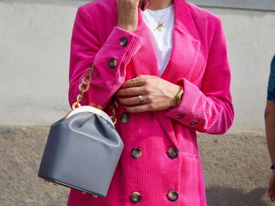 A woman wears a hot-pink coat